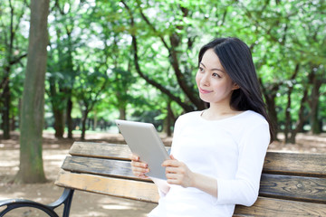 公園でタブレットPCを使う女性