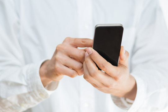 Close-up image of a man holding a mobile smartphone