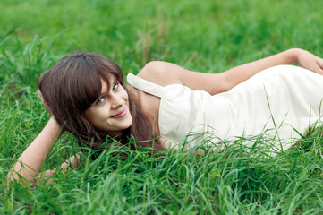Naklejka na ściany i meble Teenager girl lying on the grass