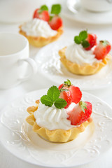 Tartlets with whipped cream and strawberries.