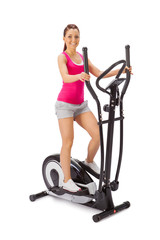 Young woman uses elliptical cross trainer. - obrazy, fototapety, plakaty