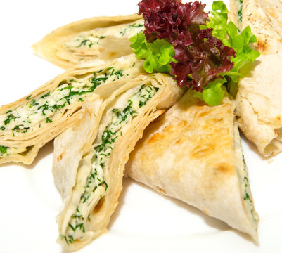 Grilled pita bread with feta cheese and herbs on plate,