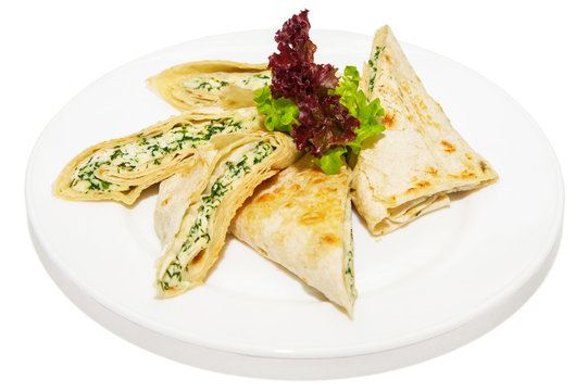 Grilled pita bread with feta cheese and herbs on plate,