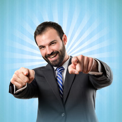 Businessman pointing to the front over blue background