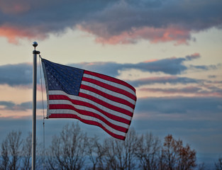 Stars and Stripes flying high against a colorful sky on the Blue Ridge of Virginia