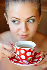 Beautiful woman holds the cup of cowberry tea