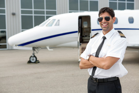 Smiling Pilot Standing In Front Of Private Jet