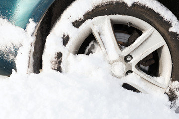 closeup of car wheel stuck in snow