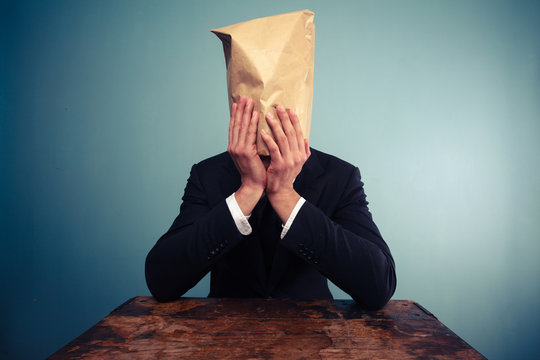 Upset businesman with bag over his head