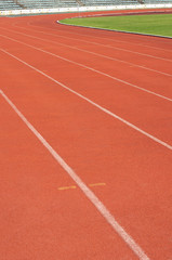Orange racecourse with white line and green yard