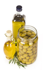 Green olives preserved in bank, bottle of olive oil, rosemary