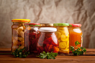 Composition with jars of pickled vegetables. Marinated food.