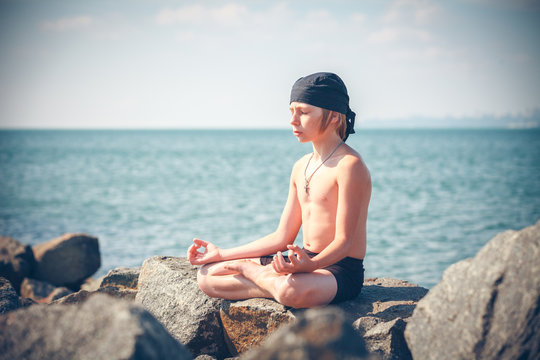 Young Boy Practising Yoga On Beach