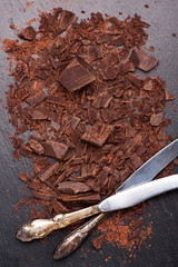 chocolate pieces and grated chocolate on a slate chalkboard