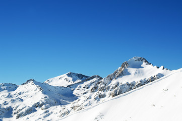 Snowcapped mountain peaks at blue sky