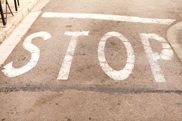 stop painted on asphalt outdoor