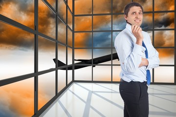 Composite image of thinking businessman holding pen