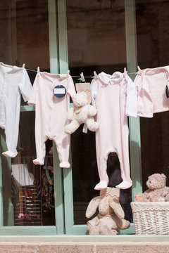 kleine baby strampler auf der w&auml;scheleine im schaufenster