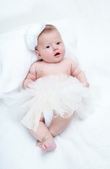 Portrait of a baby girl with a flower on her head on a white bac