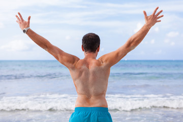 Fototapeta na wymiar sportlicher junger mann in badehose am strand im urlaub