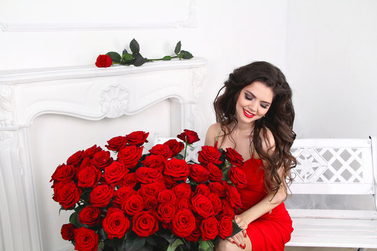 Beautiful smiling brunette woman with red roses bouquet, valenti