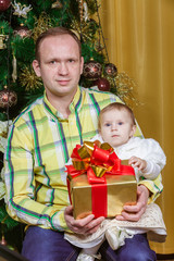 Happy father and child near Christmas fir-tree