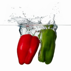 Fresh Red and Green Peppers Splash in Water Isolated on White Ba