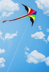 kite soars in the sky with clouds
