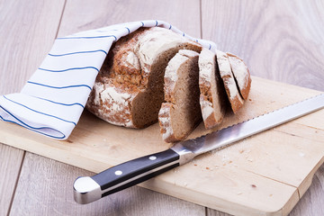 frisches hausgemachtes brot mit getreide auf holzbrett