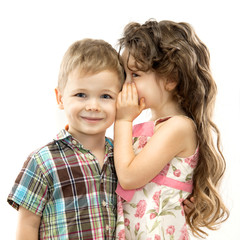 Little girl whispering something to boy