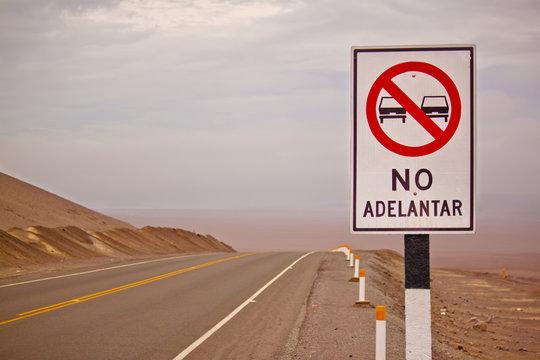 sign of "No adelantar" (Do not overtake) on a hilly road