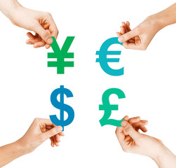 four hands holding currency symbols