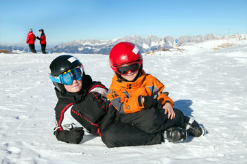Fototapeta na wymiar Two boys play on mountain summit in Alps, Kitzbuhel, Austria
