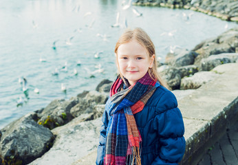 Outdoor portrait of a cute little girl next to lake