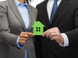 businessman and businesswoman holding green house