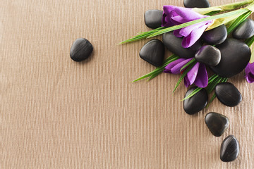 Fototapeta na wymiar massage stones with flowers on mat