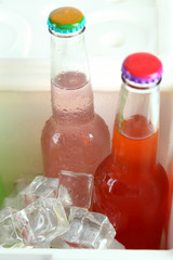 Drinks in glass bottles in mini fridge close up