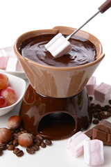 Chocolate fondue with marshmallow candies and fruits, isolated