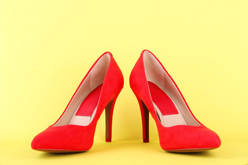 Beautiful red female shoes, on yellow background