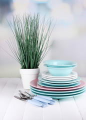 Clean dishes with flower on wooden table on natural background