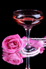 Composition with pink sparkle wine in glass and  rose isolated