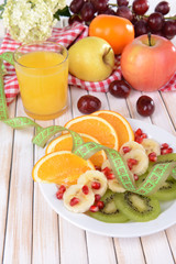 Sweet fresh fruits on plate on table close-up