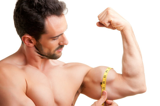 Muscular Asian man's arm flexing biceps with measuring tape Stock Photo