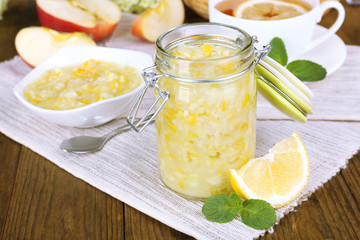 Tasty lemon jam with cup of tea on table close-up