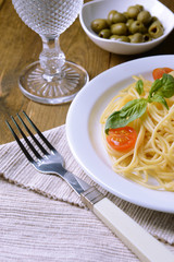 Delicious spaghetti with tomatoes on plate on table close-up