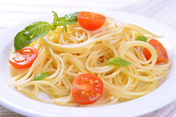 Delicious spaghetti with tomatoes on plate on table close-up