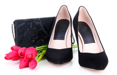 Beautiful black female shoes, bag and flowers, isolated on