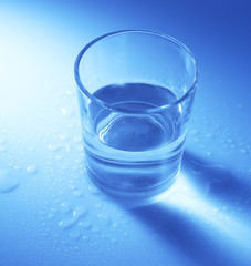 Water in  glass, on dark blue background