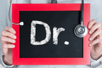 Doctor word on blackboard in doctor hands