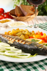 Delicious grilled fish on plate on table close-up